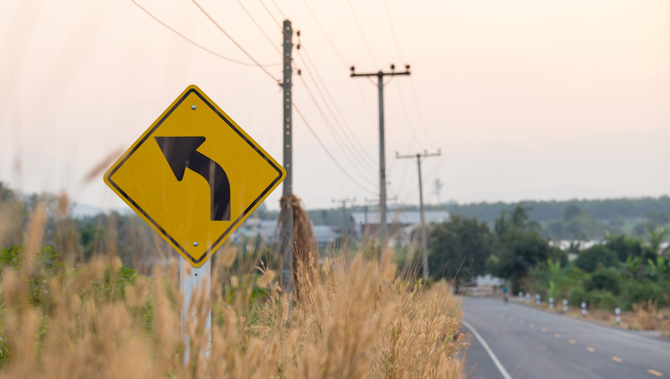 Gul trafikskylt med svart pil som pekar åt vänster.
