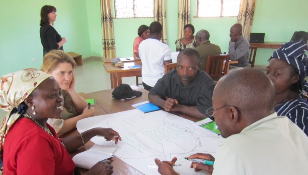 Två grupper av människor sitter vid varsitt bord och diskuterar.