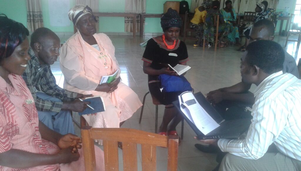 Några människor sitter i ring och diskuterar.