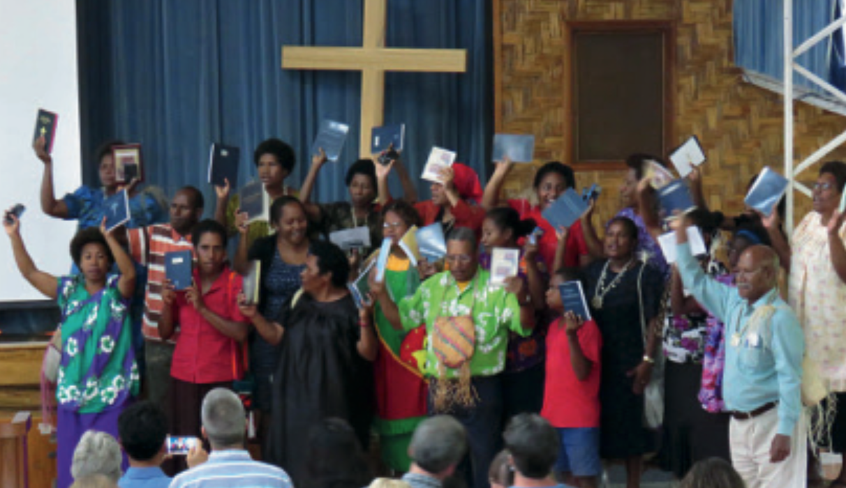 En grupp människor håller upp varsin bibel.