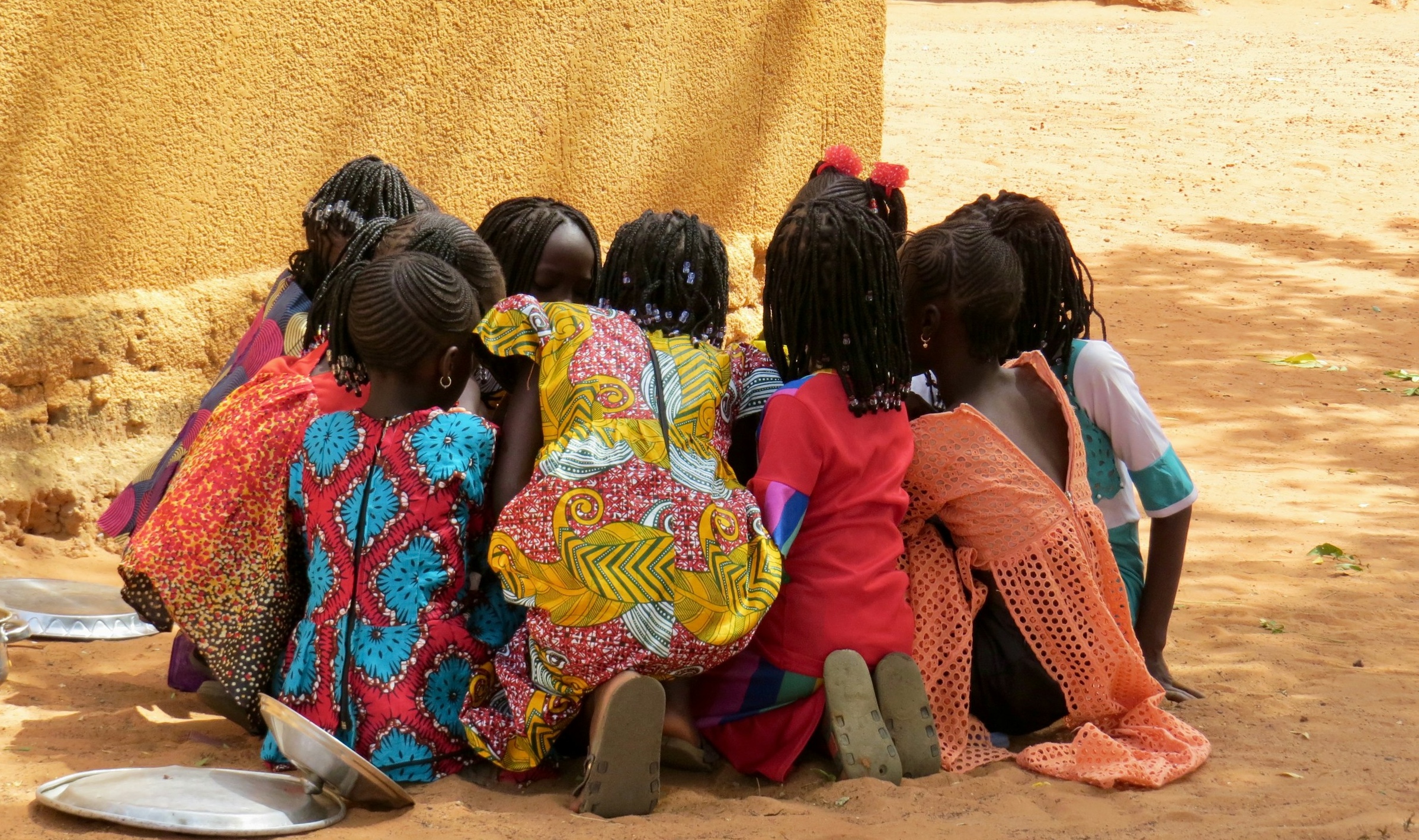 En grupp barn som sitter på marken.