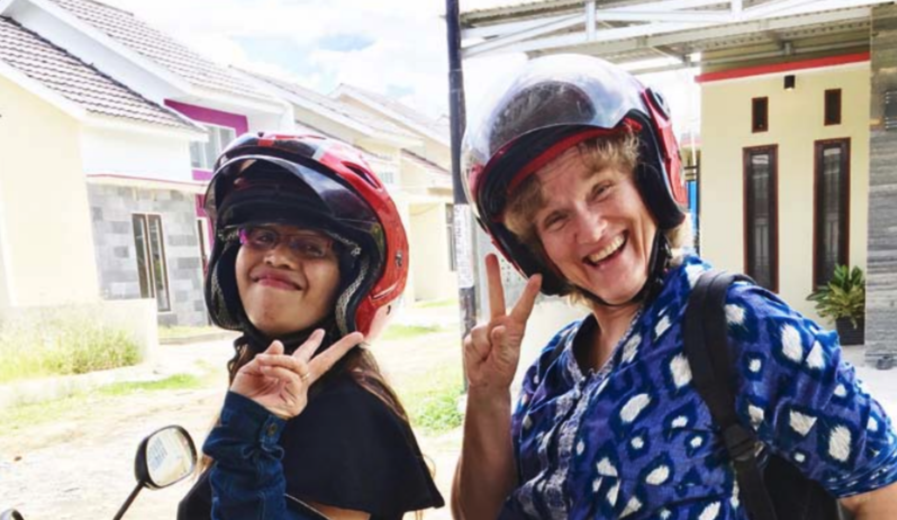 Två kvinnor sitter på en moped.