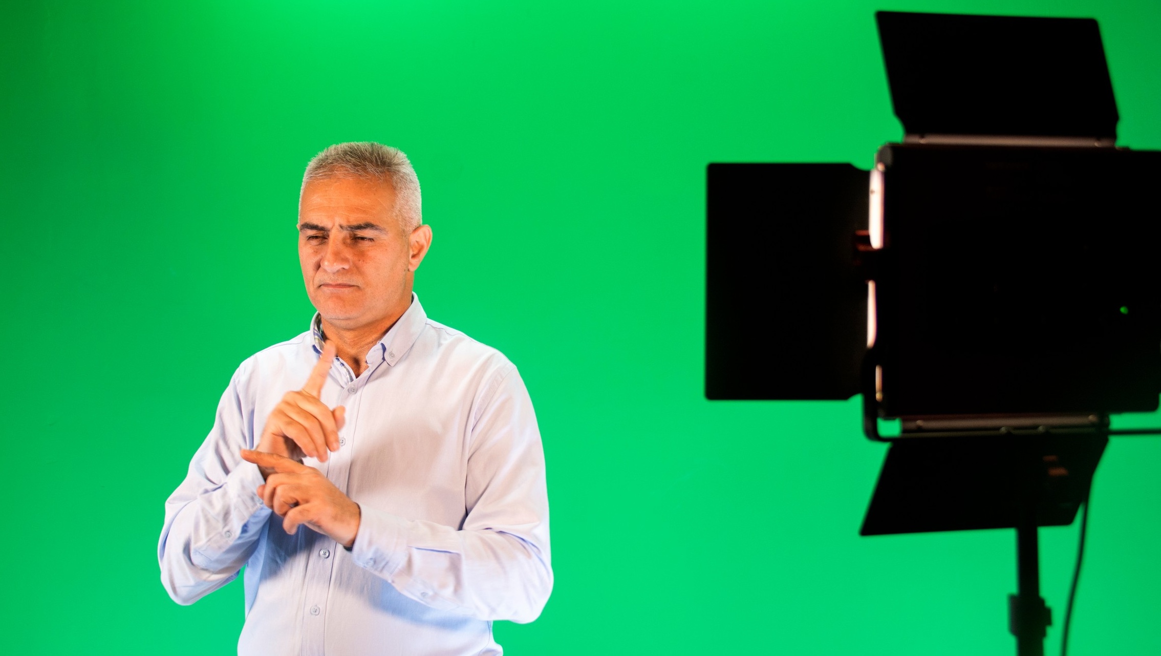 Pastor Israil spelar in teckenspråk i studio.