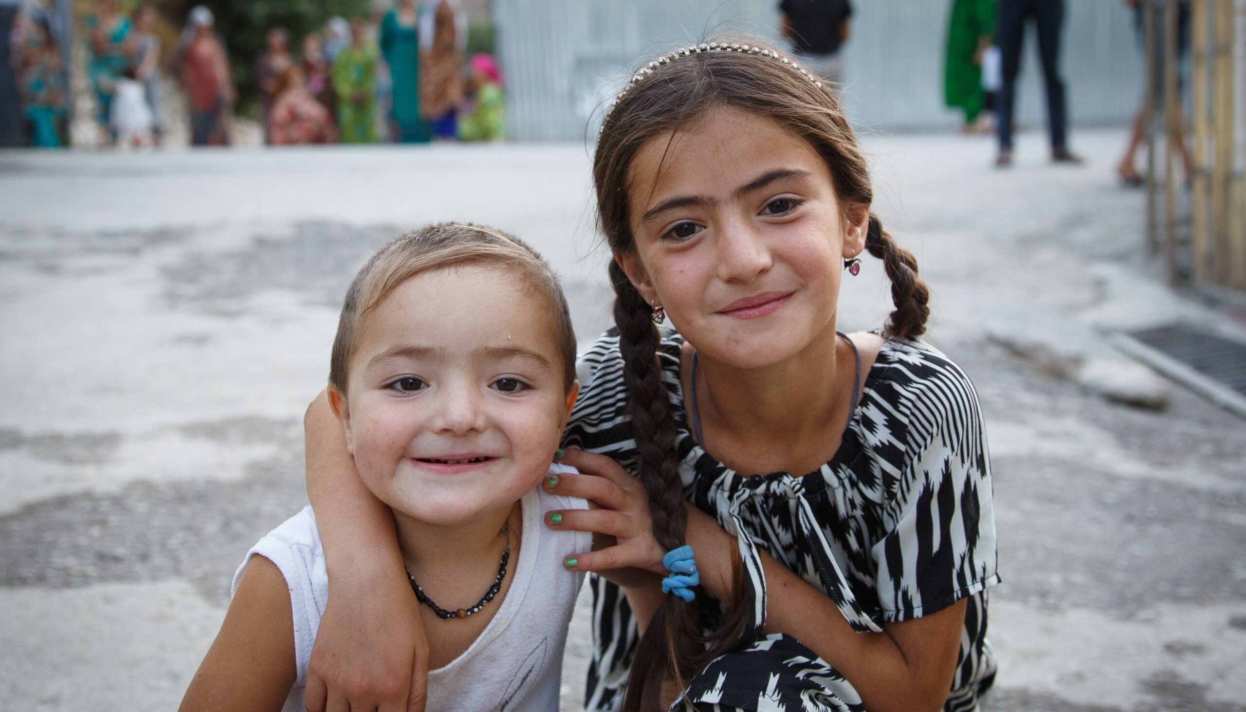 Två barn ler mot kameran.