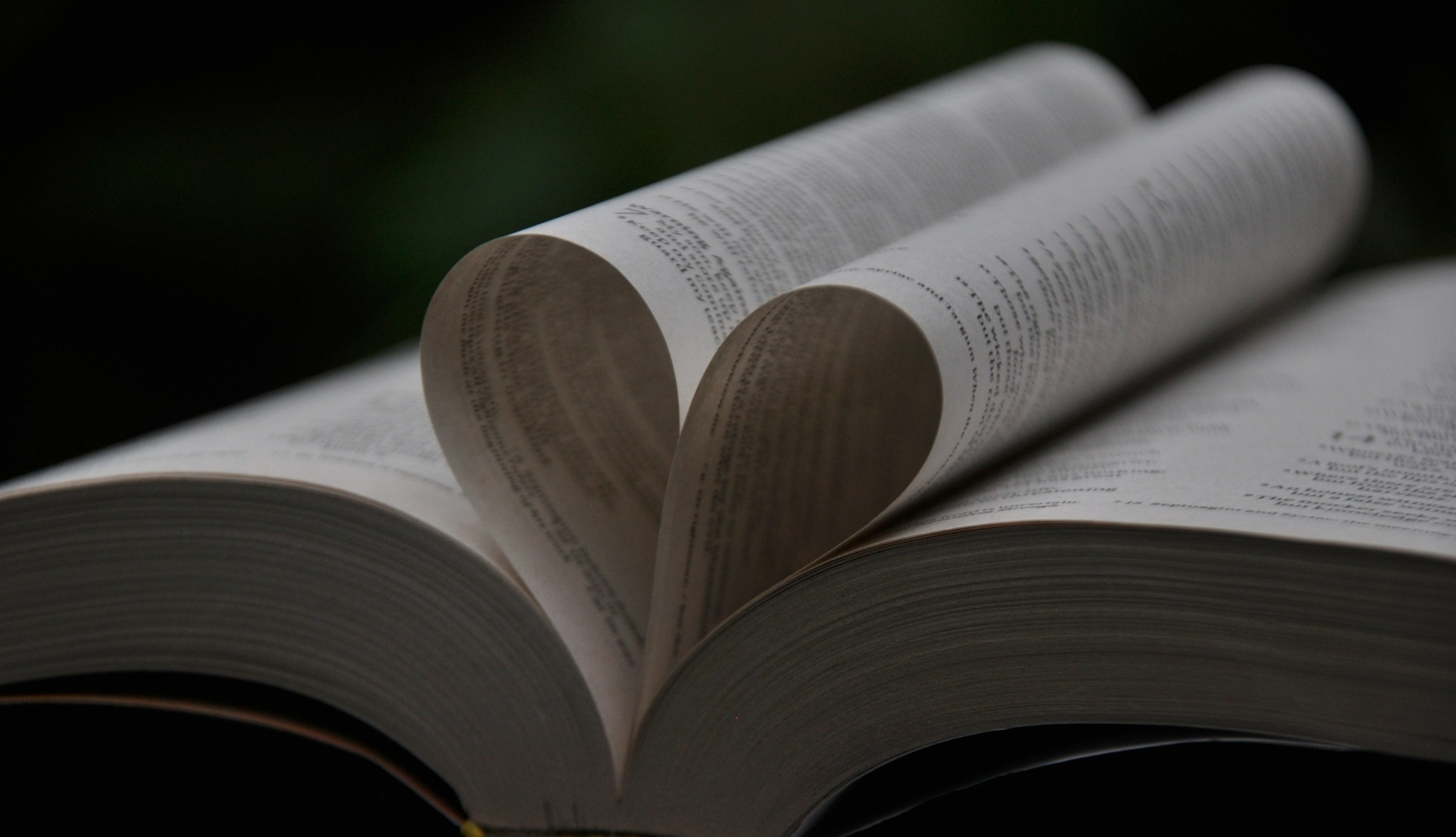 Uppslagen Bibel med två sidor vikta som ett hjärta.