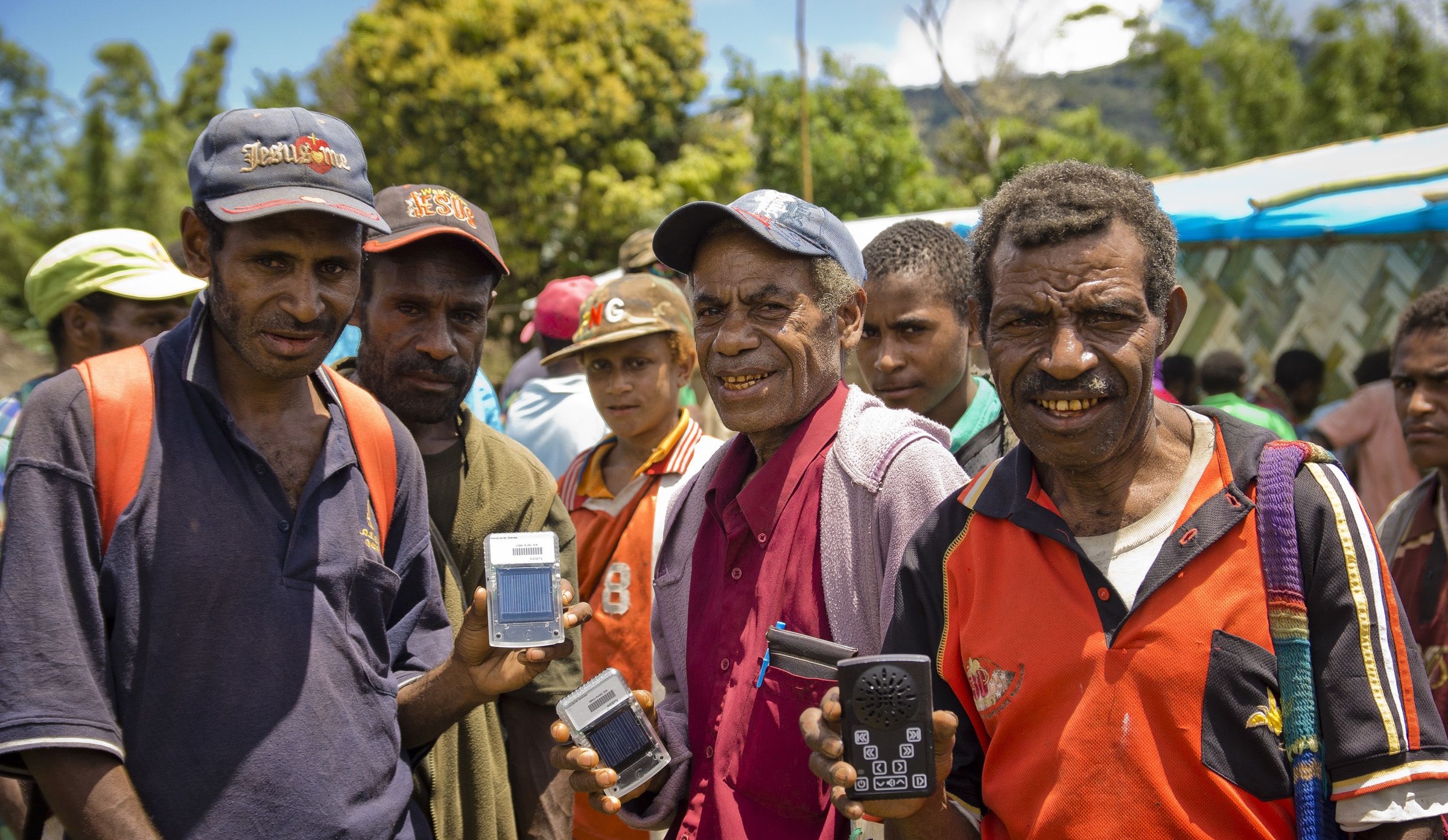 Fyra män poserar med varsin ljudboksspelare i handen.