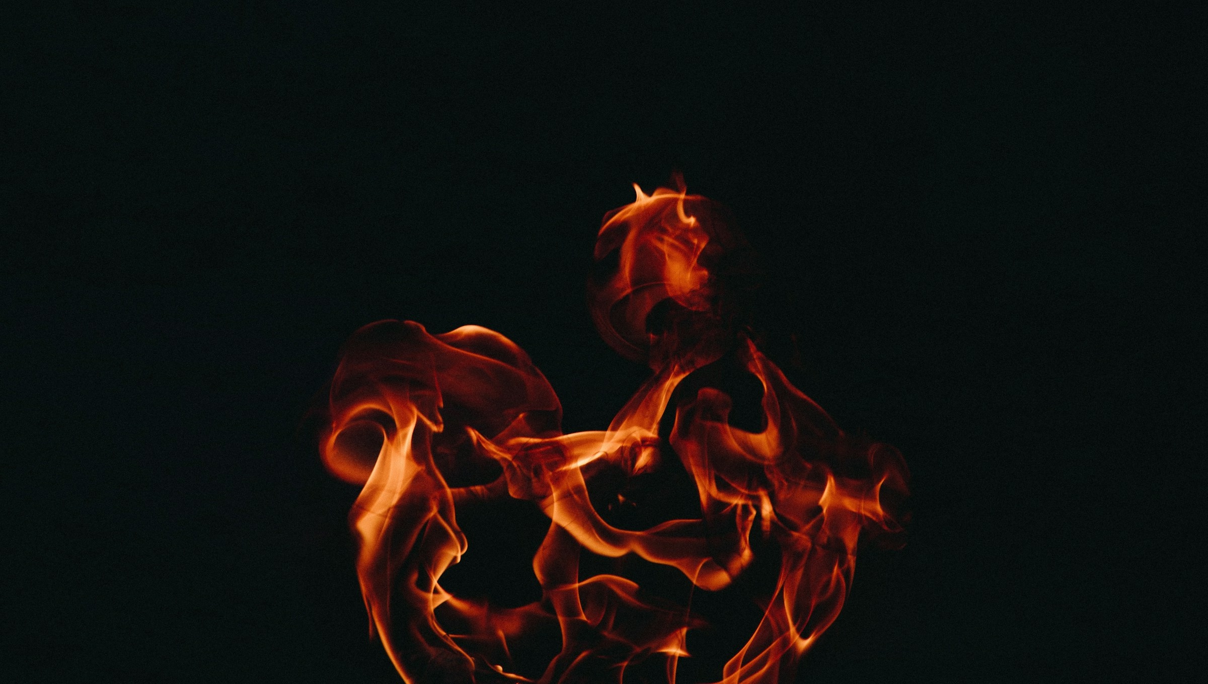 Flammande låga mot svart bakgrund.